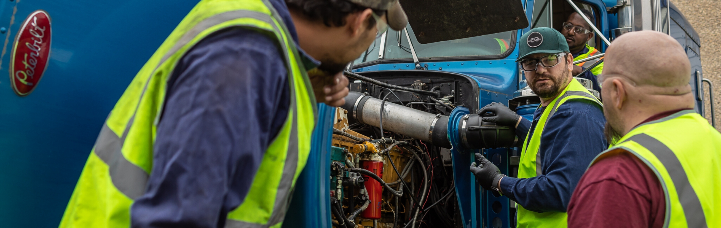  Three Diesel students and instructor working on an engine.  