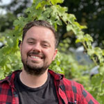 John Darin, smiling in front of greenery
