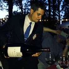 Paul Swanson pouring a glass of wine out of a huge bottle